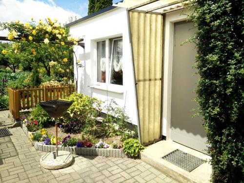 einen kleinen Garten mit Tür und Blumen in der Unterkunft Apartments Greifswalder Chaussee in Stralsund