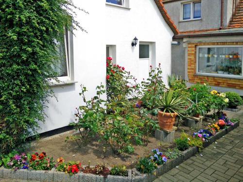 einen Garten vor einem Haus mit Blumen in der Unterkunft Apartments Greifswalder Chaussee in Stralsund