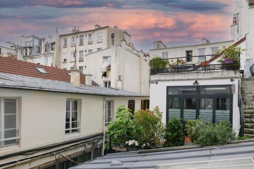 un groupe de bâtiments blancs dans une ville dans l'établissement Duplex 4 pax- cour privée, à Paris