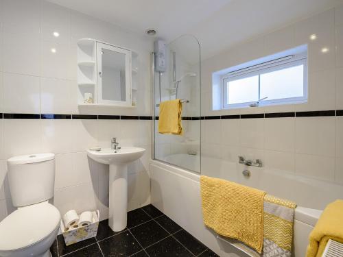 a white bathroom with a toilet and a sink at 2 bed in Langtree 79483 in Langtree