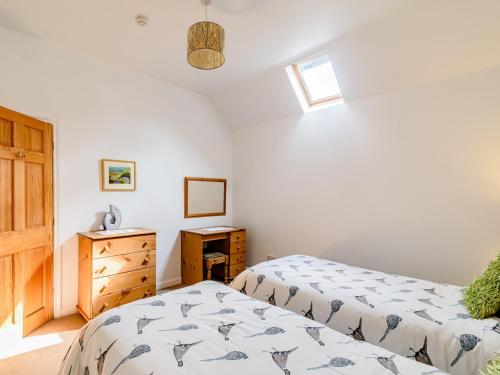 a bedroom with two twin beds and a dresser at 2 Bed in Filey 79280 in Wold Newton