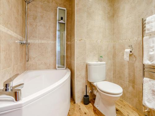 a bathroom with a toilet and a tub and a sink at 3 bed property in Bath 79174 in Chilcompton