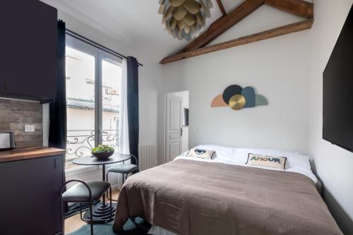 une chambre avec un lit, une table et une fenêtre dans l'établissement Au centre de paris - 4pax, à Paris