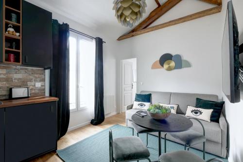 uma sala de estar com um sofá e uma mesa em Au centre de paris - 4pax em Paris