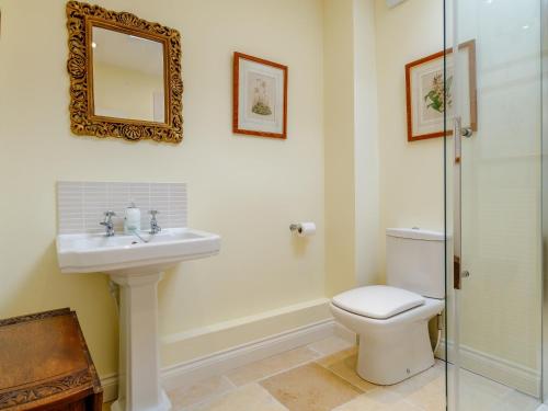 a bathroom with a toilet and a sink and a mirror at 3 Bed in Frampton on Severn 80634 in Frampton on Severn