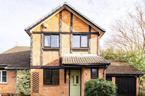 an old brick house with a green door at Ratby House - Spacious 3 Bed with Garden & Parking in Earley