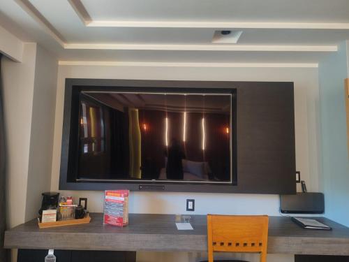 a large flat screen tv on a wall at Suites Inn la Muralla Hotel & Spa in Toluca