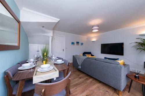 a living room with a blue couch and a table at Ratby House - Spacious 3 Bed with Garden & Parking in Earley