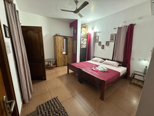 a bedroom with a bed with a pink blanket at Maass Homestay in Puducherry