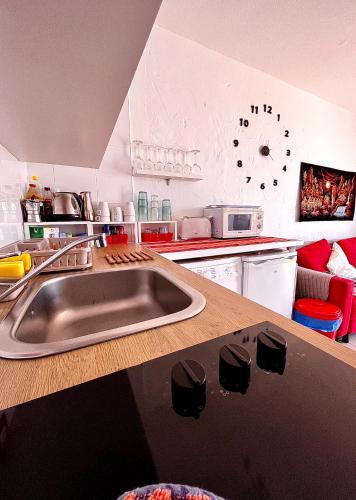 a kitchen with a sink and a clock on the wall at La Casita Sun Beach in Caleta De Fuste
