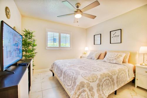 a bedroom with a bed and a flat screen tv at VILLA FOUR PALMS - 3 BEDS - 2 BATHS - 6 GUESTS - GULF ACCESS & POOL - INCL.10% OFF BOAT RENTAL in Cape Coral