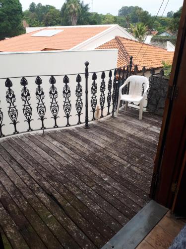 a white chair sitting on a porch with a fence at Terapias integrativas do Sandrin in Jundiaí