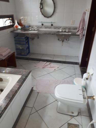uma casa de banho com um WC branco e um lavatório. em Terapias integrativas do Sandrin em Jundiaí