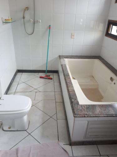 a bathroom with a toilet and a bath tub at Terapias integrativas do Sandrin in Jundiaí