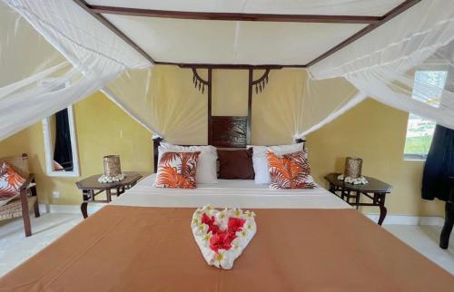 a bedroom with a large bed with fruit on it at Barracuda Inn Resort in Watamu