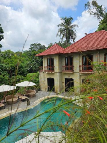 uma casa com uma piscina em frente em The Gana Ubud by Guru experience em Ubud