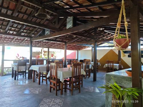 a dining room with tables and chairs in a restaurant at Pousada Villa Graciela in Ilhéus