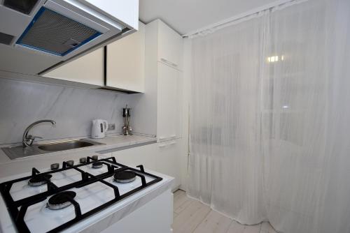 a white kitchen with a stove and a sink at Apartmentrent in Chişinău