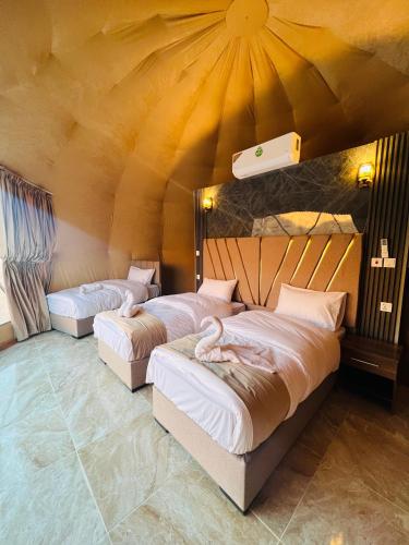 a room with two beds in a tent at Sand Star Camp in Wadi Rum