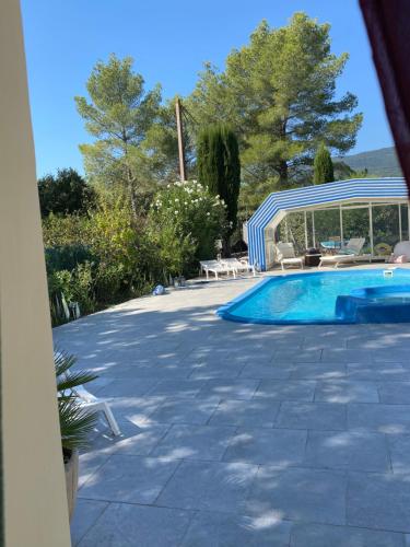 a swimming pool in a yard with chairs and a swimming pool at maisonette Cosi in Fayence