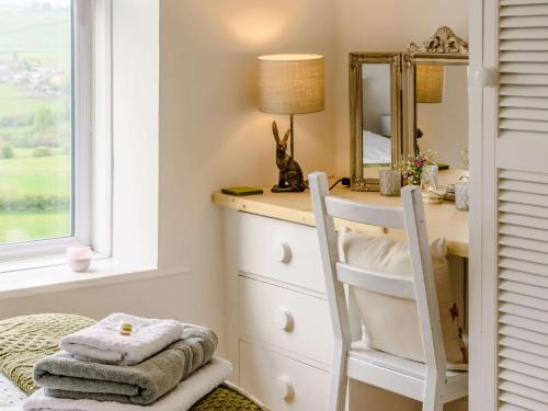 ein Badezimmer mit einem Schreibtisch, einem Spiegel und einem Stuhl in der Unterkunft 4 bed in North York Moors 82262 in Danby