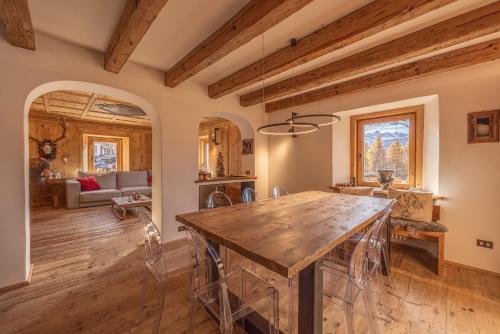 a kitchen and living room with a wooden table at Casa Alvera Dream in Cortina dʼAmpezzo