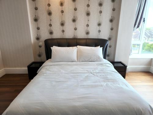 a bed with a black headboard in a bedroom at D'Getaway - Kuching Prime Area - Family Oasis - Spacious Condo in Kuching