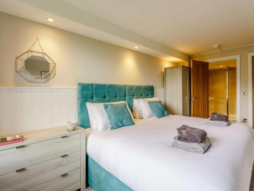 um quarto com uma cama grande e uma cabeceira azul em 2 Bed in Skipton 83162 em Cononley