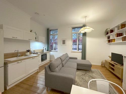 a living room with a couch and a kitchen at L'Artoisienne • Parking sécurisé & Wifi fibre in Douai