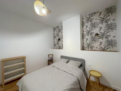 a bedroom with a bed and a picture on the wall at L'Artoisienne • Parking sécurisé & Wifi fibre in Douai