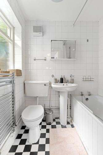 a bathroom with a toilet and a sink and a tub at Russell Square Vintage - 2 Cozy Bed Home in London