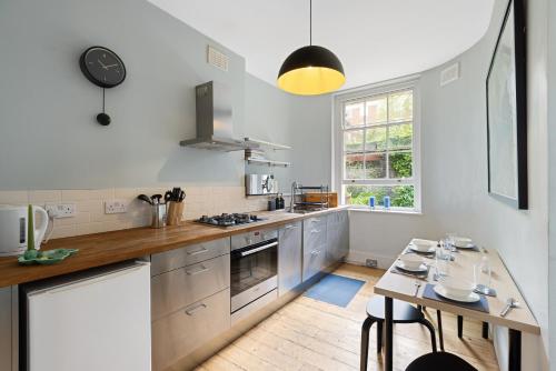 a kitchen with a counter and a table in it at Russell Square Vintage - 2 Cozy Bed Home in London