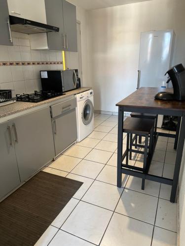 une cuisine avec une table et un réfrigérateur dans l'établissement Appartement Climatisé La Gallinette, à Perpignan