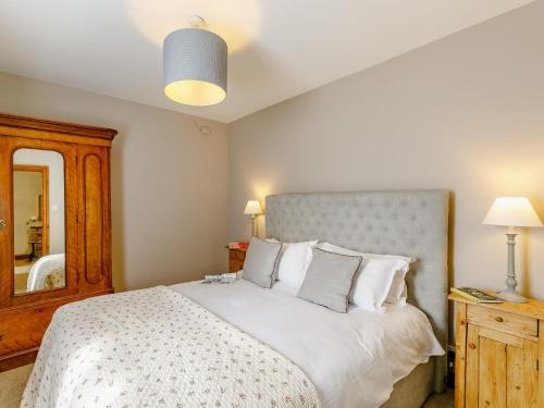 a bedroom with a large white bed with a mirror at 1 bed property in Easingwold 84002 in Crayke