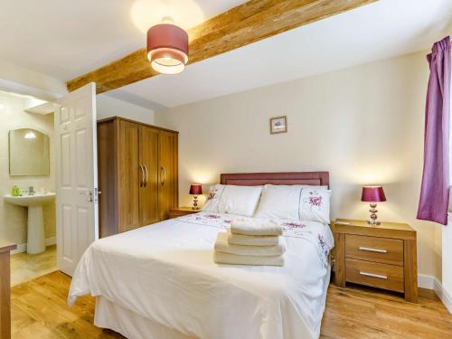 een slaapkamer met een wit bed en handdoeken bij 3 bed in Bagillt 83813 in Bagilt