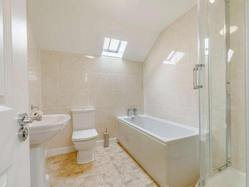 a bathroom with a tub and a toilet and a sink at 3 bed in Bagillt 83813 in Bagillt