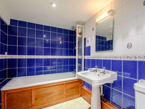a blue tiled bathroom with a tub and a sink at 1 bed in Eskdale SZ503 in Beckfoot