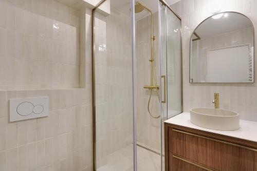 une salle de bain avec douche et lavabo dans l'établissement Pick A Flat's Apartment in Saint-Germain - Rue de Sèvres, à Paris