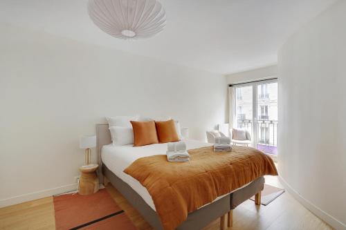 une chambre avec un lit et une grande fenêtre dans l'établissement Pick A Flat's Apartment in Saint-Germain - Rue de Sèvres, à Paris