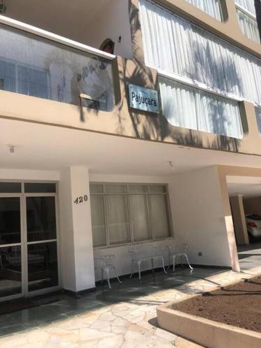 budynek z dwoma stołami przed nim w obiekcie Apartamento - Enseada Guarujá SP w mieście Guarujá