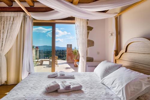 a bedroom with a bed with two towels on it at Villa Kois by PosarelliVillas in Tzitzifés