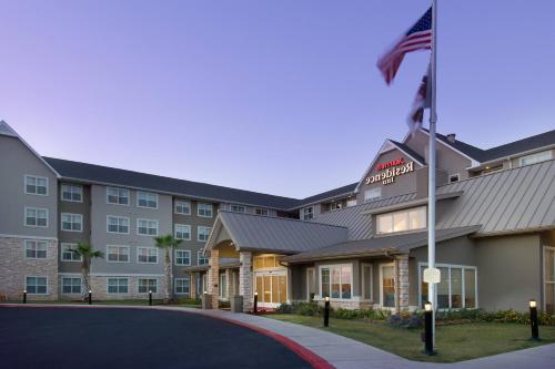 a hotel with an american flag in front of it at Residence Inn by Marriott San Antonio SeaWorld / Lackland in San Antonio