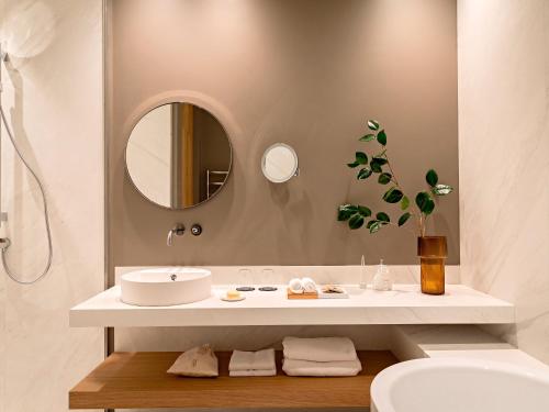 a bathroom with a sink and a mirror at Domaine de la Reine Margot Paris-Issy - MGallery Collection in Issy-les-Moulineaux