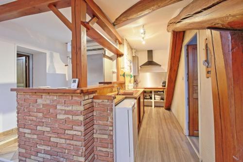 Il comprend une cuisine dotée d'un mur en briques et de poutres apparentes. dans l'établissement Le Guerin - Parking et Centre, à Nîmes