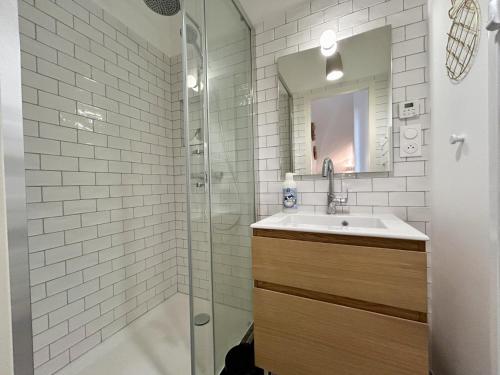 une salle de bain blanche avec un lavabo et une douche dans l'établissement Maison Pasteur, maison de pêcheur entièrement rénovée pour 6 personnes, au Crotoy