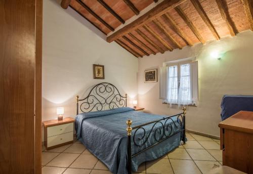 een slaapkamer met een bed met een blauwe sprei en een raam bij Il Campo Comfort apt with balcony in Siena