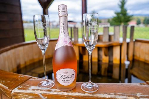 a bottle of champagne and two wine glasses on a table at Drevenica pod Sitieňom 1 in Lazisko