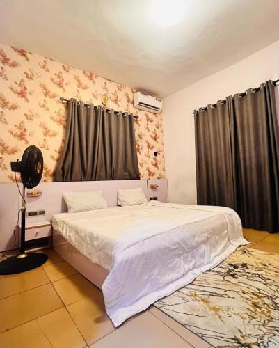 a bedroom with a white bed and a window at Petra Homes B in Lagos