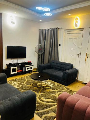 a living room with two couches and a tv at Petra Homes B in Lagos