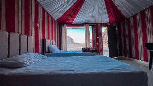 a bedroom with two beds and a view of the desert at Rehana rum camp in Wadi Rum